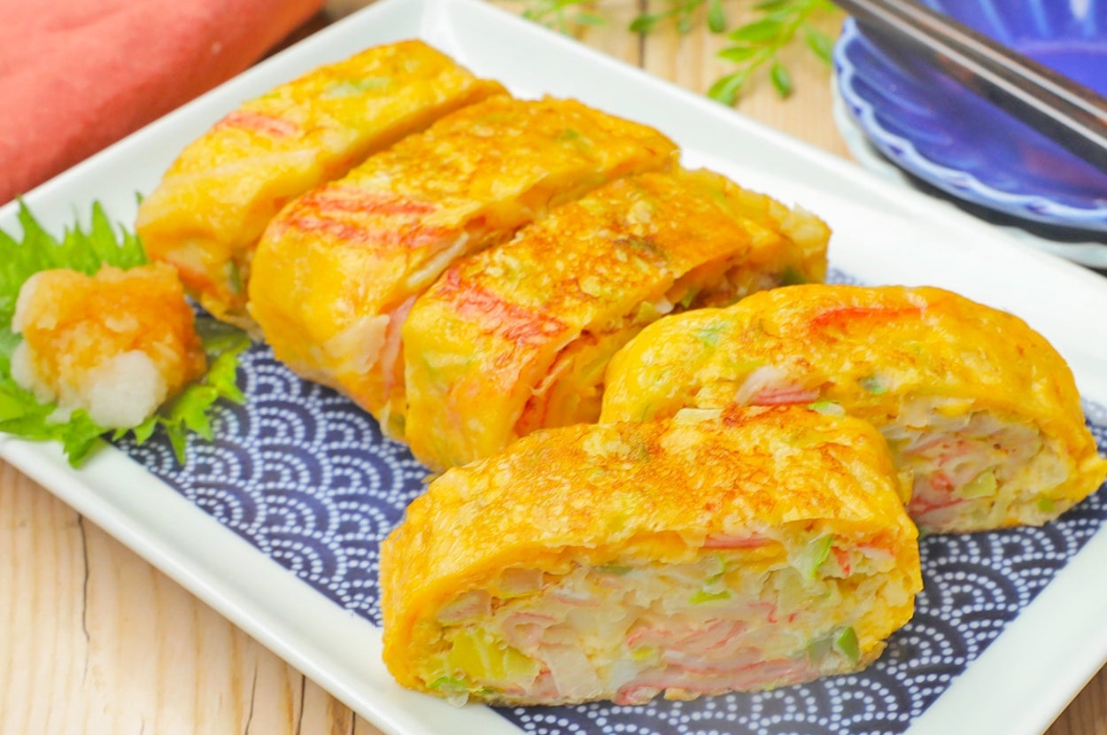 卵焼きに巻かれたカニカマと野菜が切り分けられ、皿に盛られている。