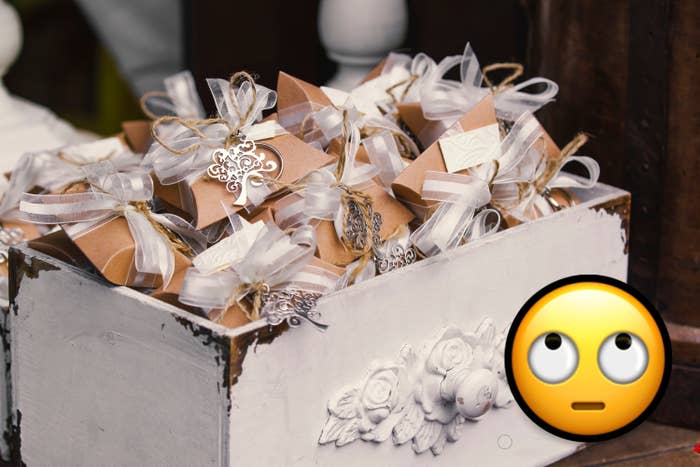 A decorative container filled with elegantly wrapped wedding favors featuring ribbons and intricate ornament designs