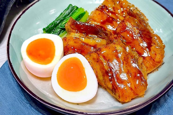 皿に盛られた焼きナス、ゆで卵、青菜の料理。