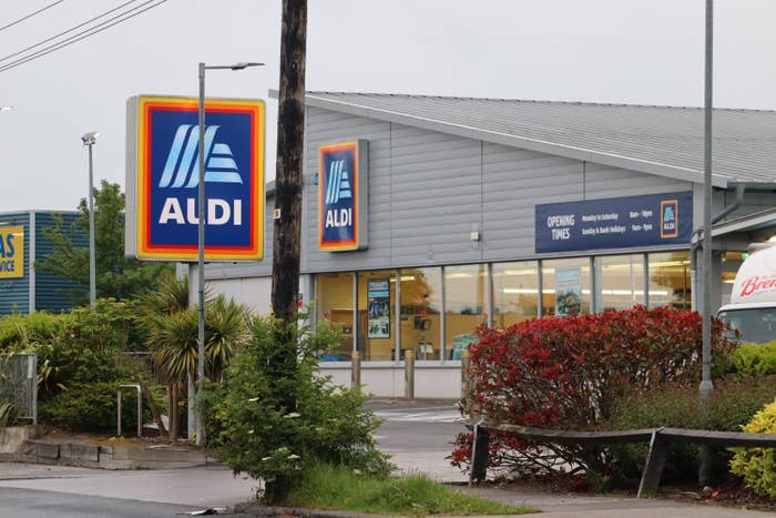 Aldi storefront with signage and entrance, surrounded by greenery and a parking area