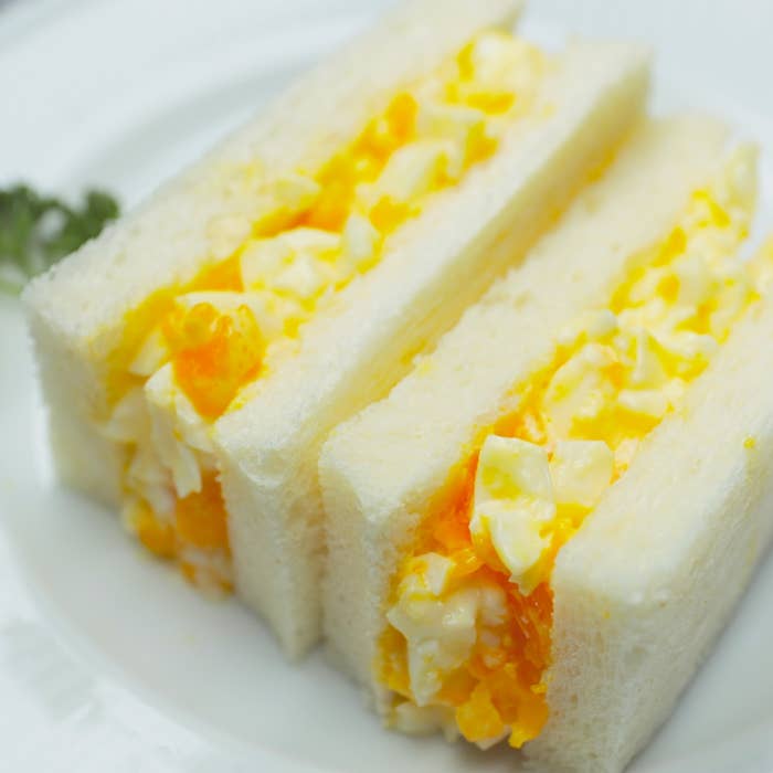 白いプレートに載った卵サンドイッチが三つ並んでいます。シンプルで美味しそうな見た目です。