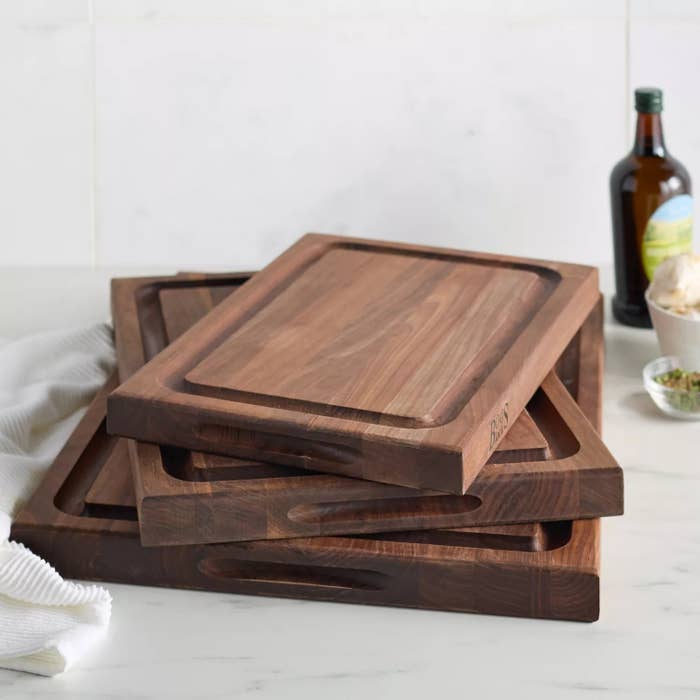 Stack of woody cutting boards connected a room antagonistic with an lipid vessel and a cloth nearby, suggesting a room setting