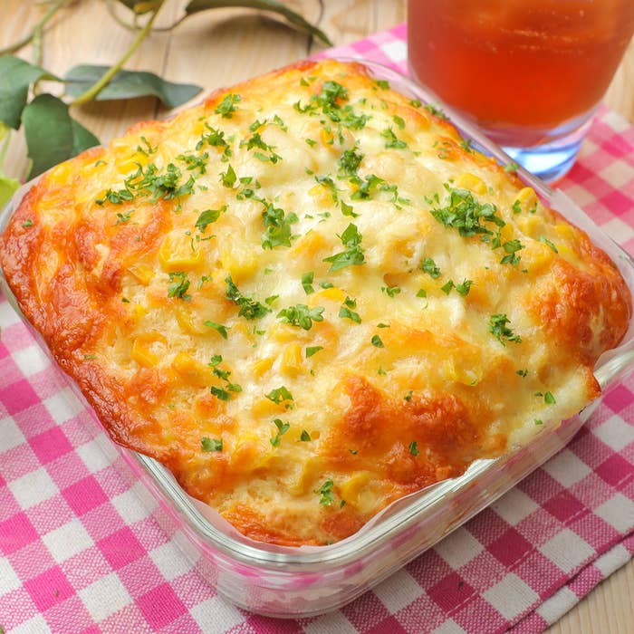 焼きたてのチーズがたっぷり乗ったグラタンがテーブルに置かれている。隣にアイスティーがある。