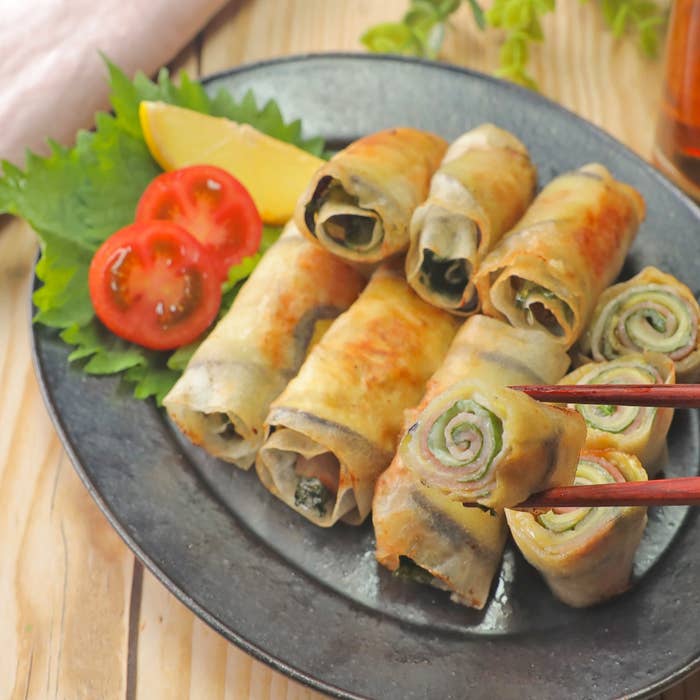 春巻きが皿に盛られている。添え物としてトマトのスライスとレモン。食べる直前の様子。
