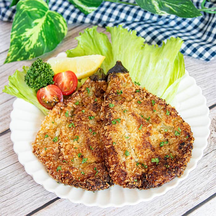 皿に盛られた揚げもの、レタス、ミニトマト、レモンで彩られる料理。
