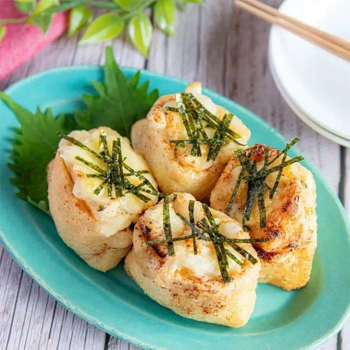 青い皿に盛られた油揚げ料理、美しく盛り付けられたのりが上に載せられている。料理は和食スタイル。