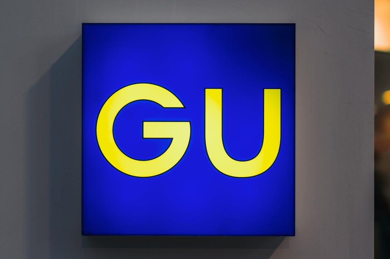Illuminated store sign with the letters "GU."