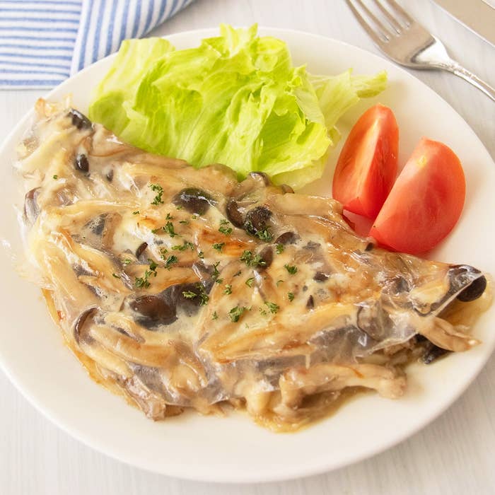 きのことチーズのライスペーパー挟み焼きがレタスとトマトと共に白いプレートに盛られている。