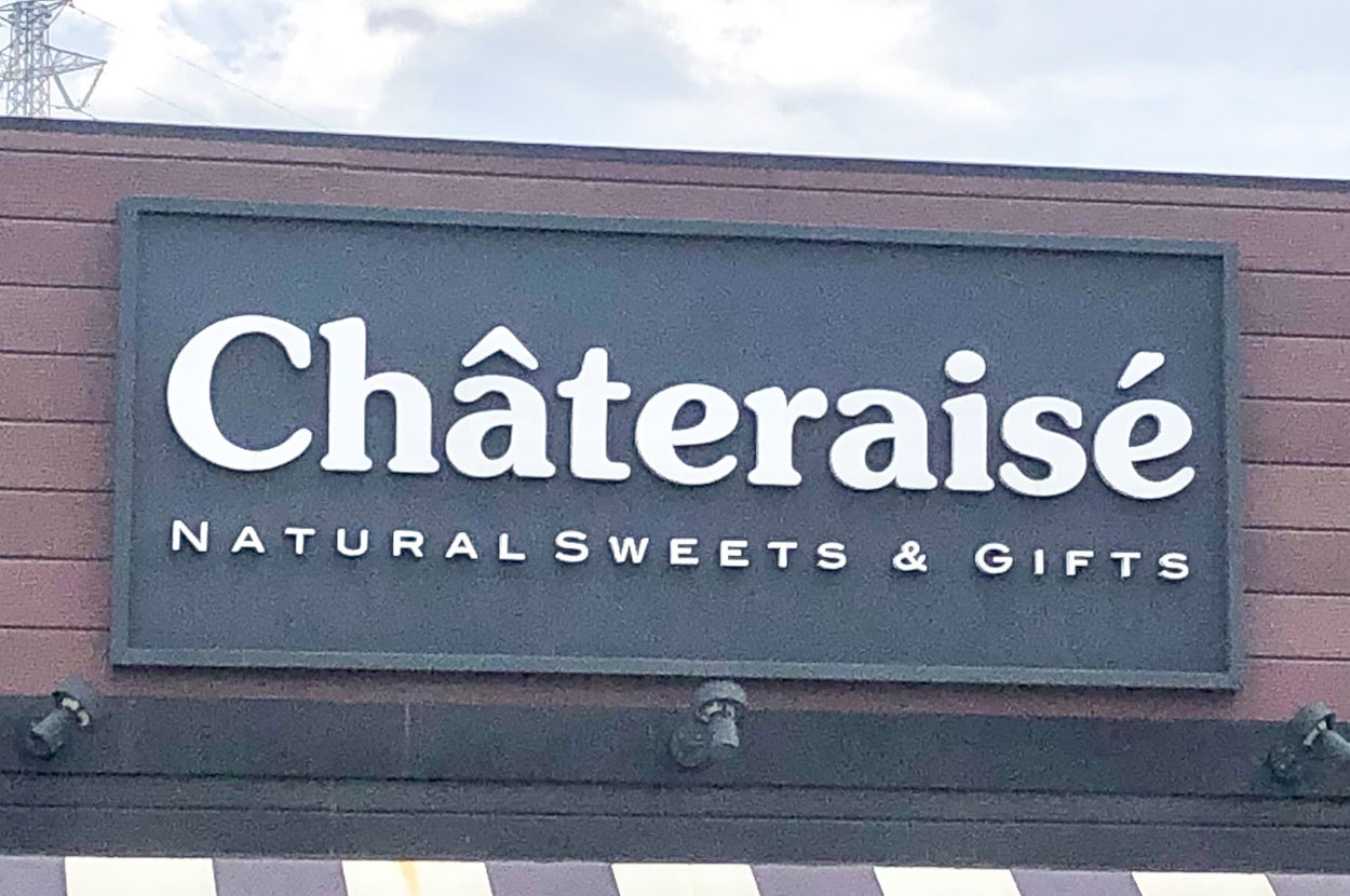 洋菓子店「シャトレーゼ」の看板。上部に「Chateraise」、下部に「NATURAL SWEETS & GIFTS」と表示。店舗外観が見える。