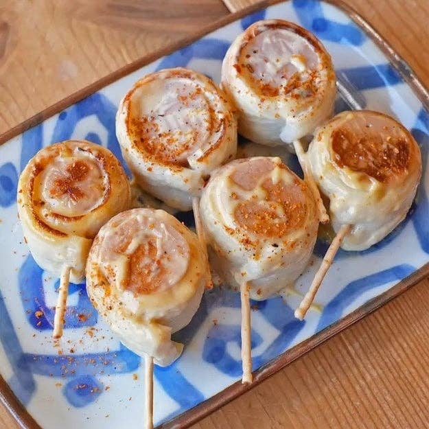料理の串に刺された数個の焼き餃子が皿に盛られている。