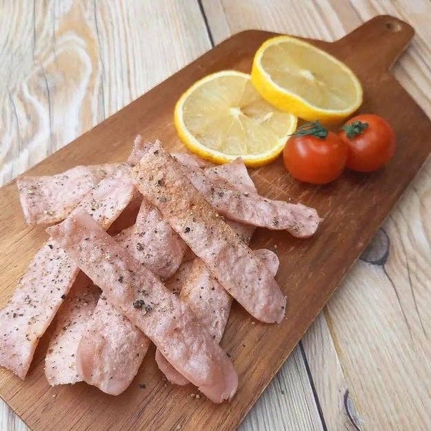カットレモン、ミニトマト、ペッパー付きチキンがまな板に盛り付けられている。