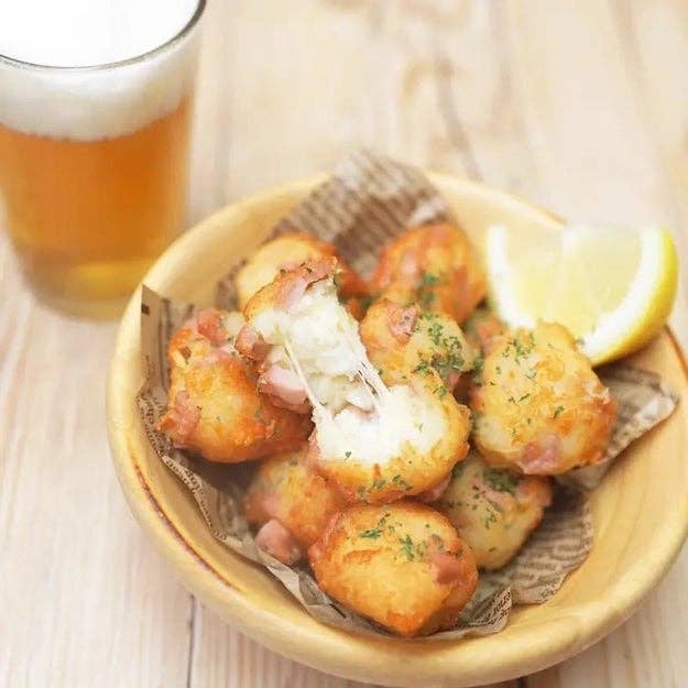 ビールの隣に、新聞紙の上に盛られたタラのフライがレモンと一緒に皿にのっている。