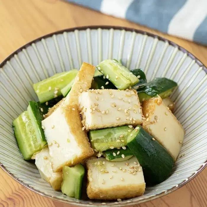 きゅうりと揚げ豆腐のサラダが器に盛られている。胡麻が上に散らされている。
