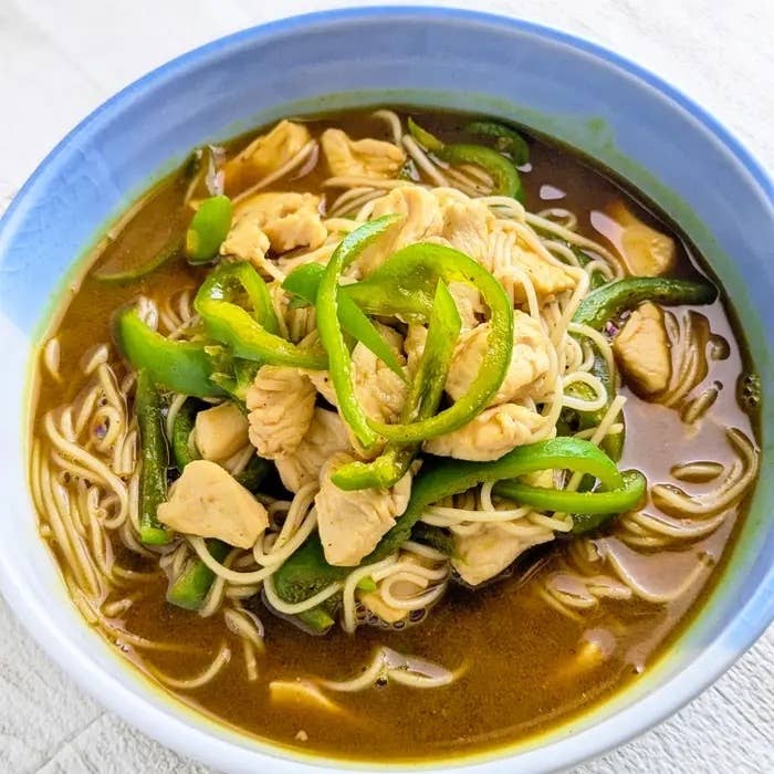 器に盛られたヌードルスープ。鶏肉とピーマンがトッピングされている。