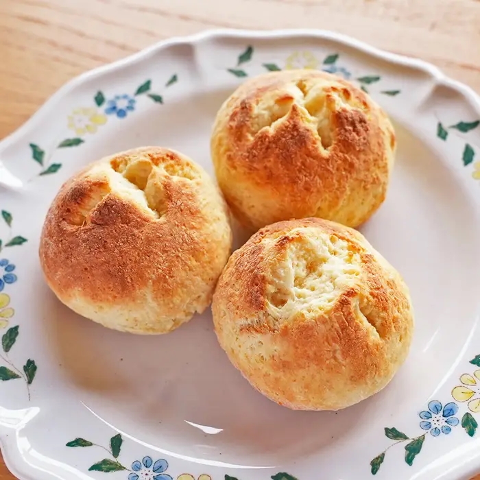 プレートの上に3つの焼きたてのパンが並んでいます。家庭的でおいしそうな見た目です。