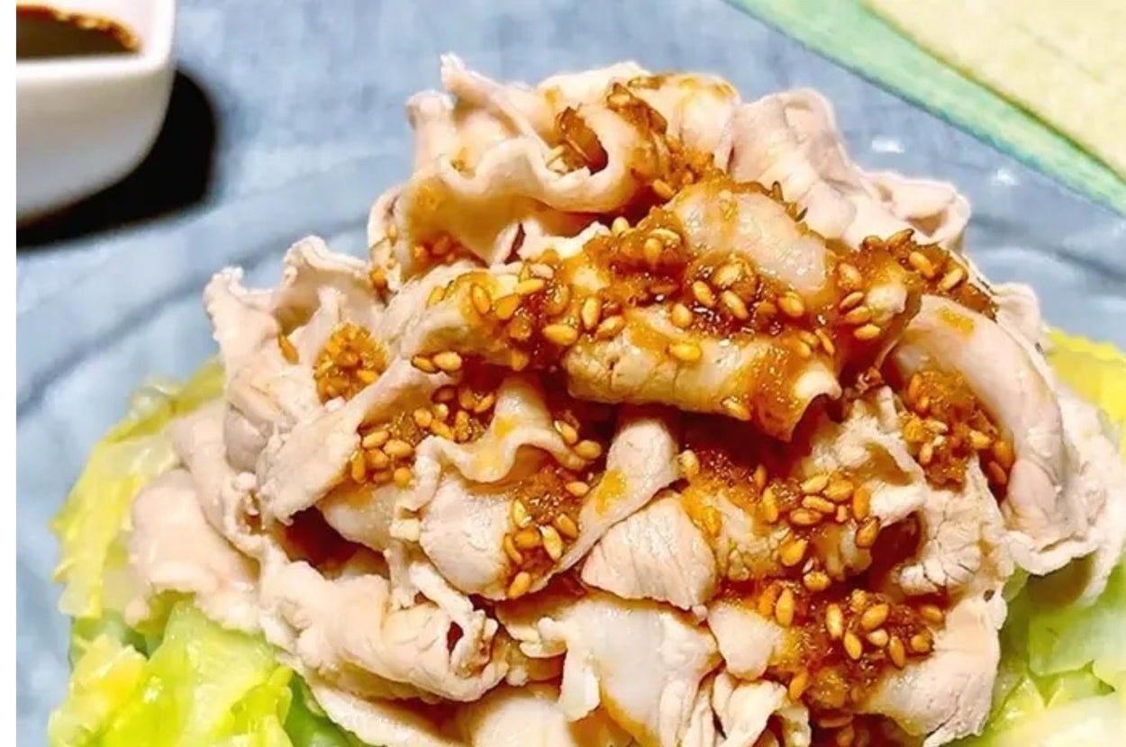 薄切り豚肉とキャベツの上にごまソースがかかった料理。シンプルで家庭的な一品。