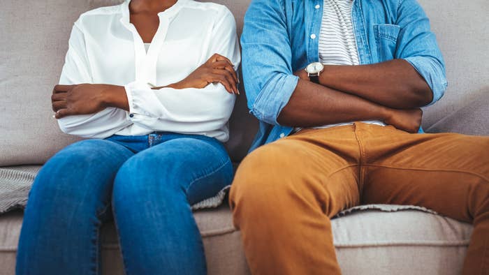 A mates sitting connected a sofa with arms crossed
