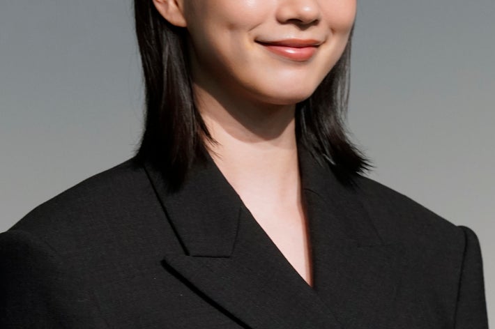 申し訳ありませんが、この画像の人物が誰かは分かりません。ダークスーツを着た女性が笑顔で写っています。