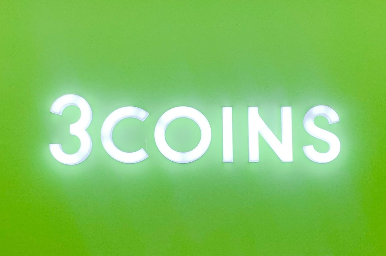 "3COINS"のサインが飾られた店舗の入り口。下に3%オフの広告が複数掲示されている。