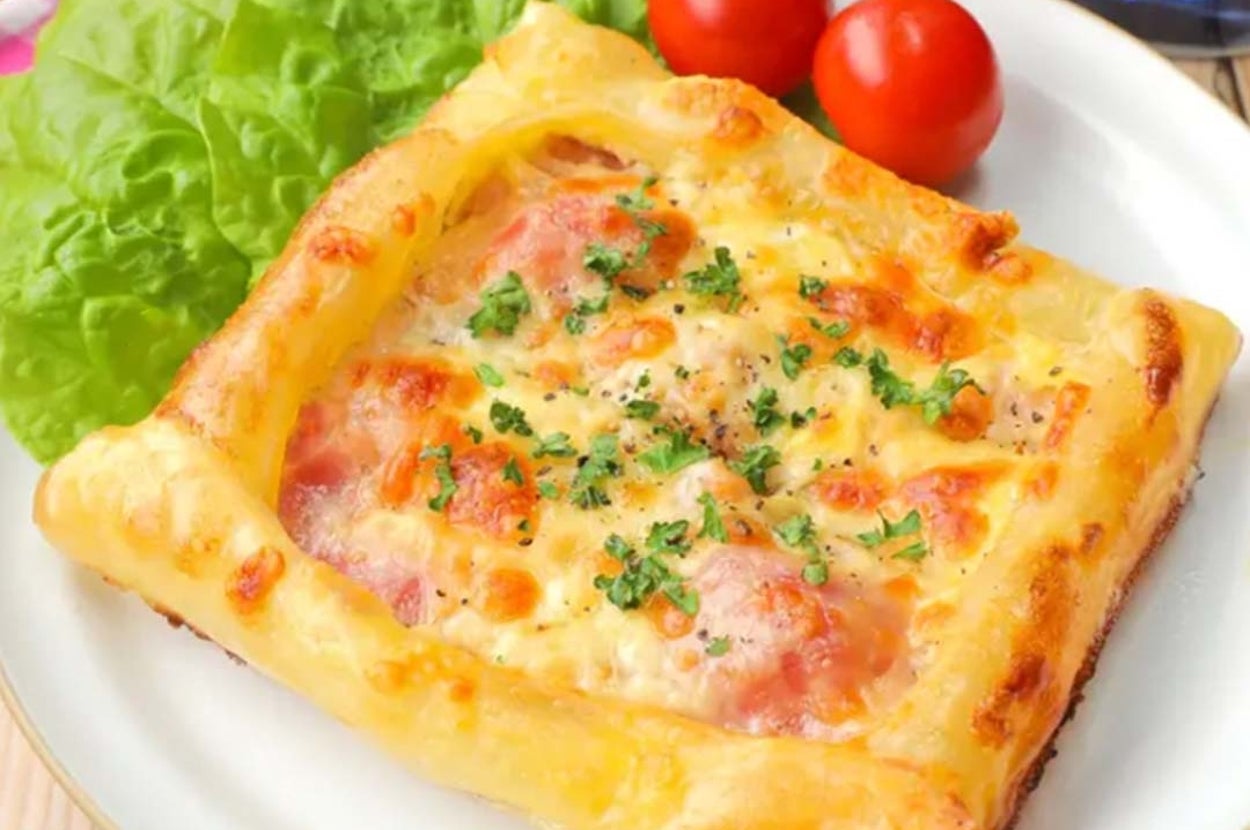 葉野菜とトマトを添えたチーズとハムのパイのプレート。