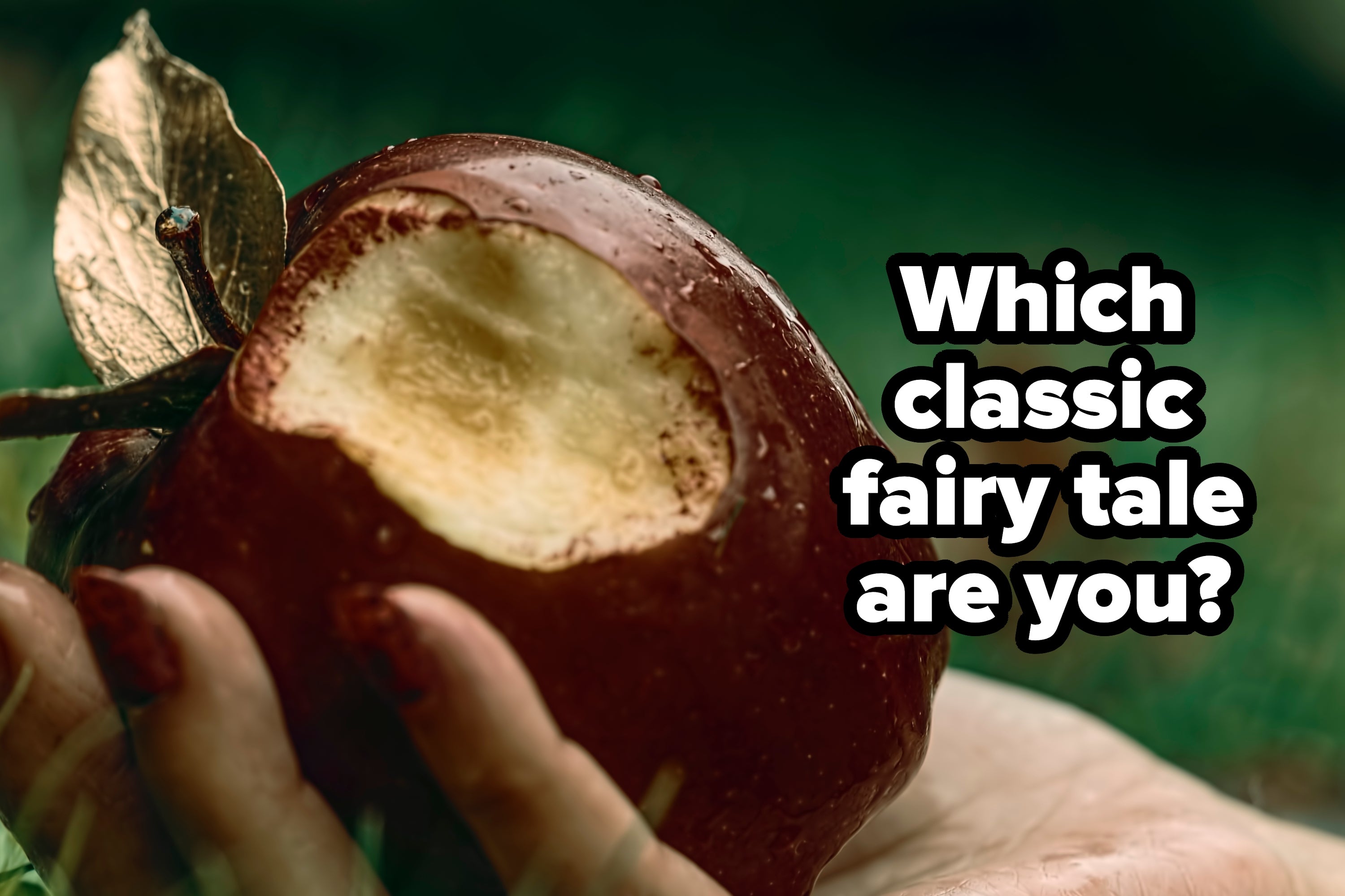 Close-up of a hand holding an apple with a big bite taken out of it. Grass is visible in the background