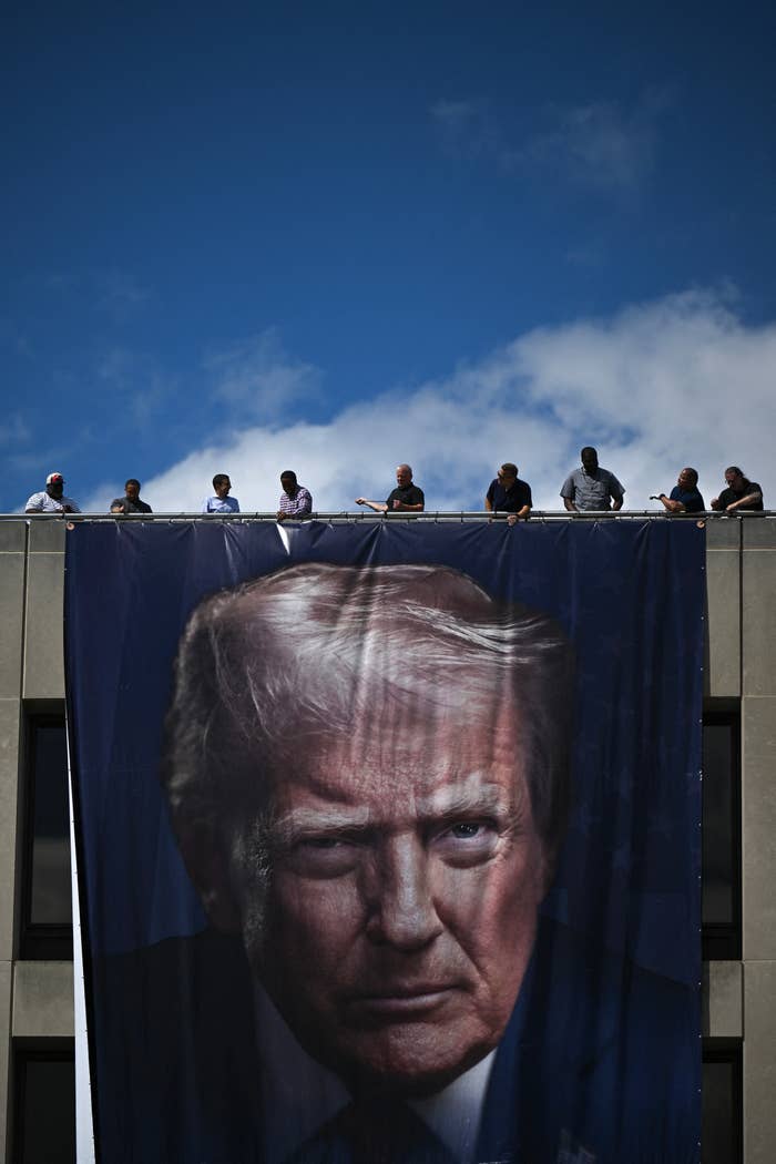 A ample banner of a salient person's look hangs connected a building, with respective radical gathered connected the rooftop above