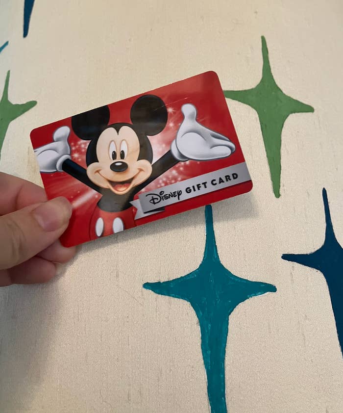 Person holding a Disney acquisition paper featuring Mickey Mouse, with a playful inheritance design