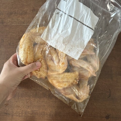 透明な袋に入った乾燥キノコを持つ手。袋にラベルが貼られている。