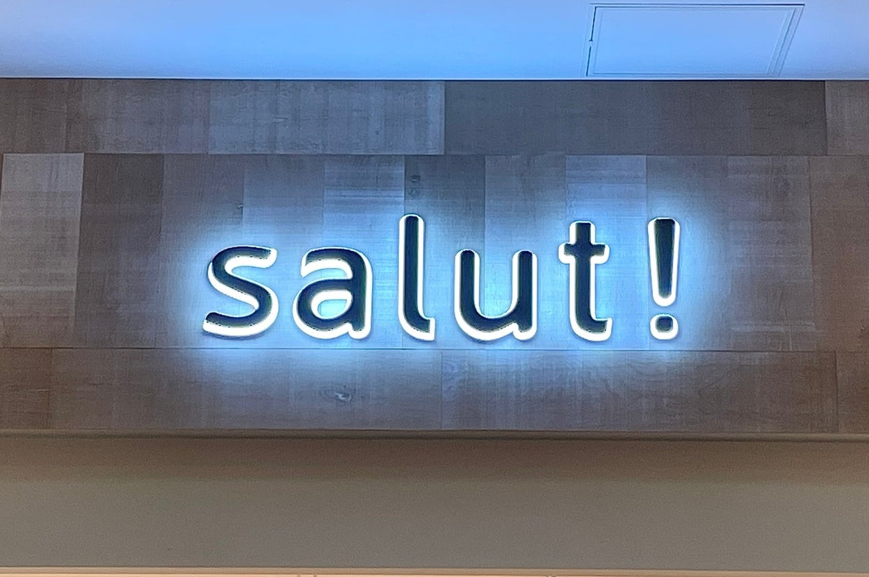 「salut!」と光る看板が店の入口上方に掲げられている。