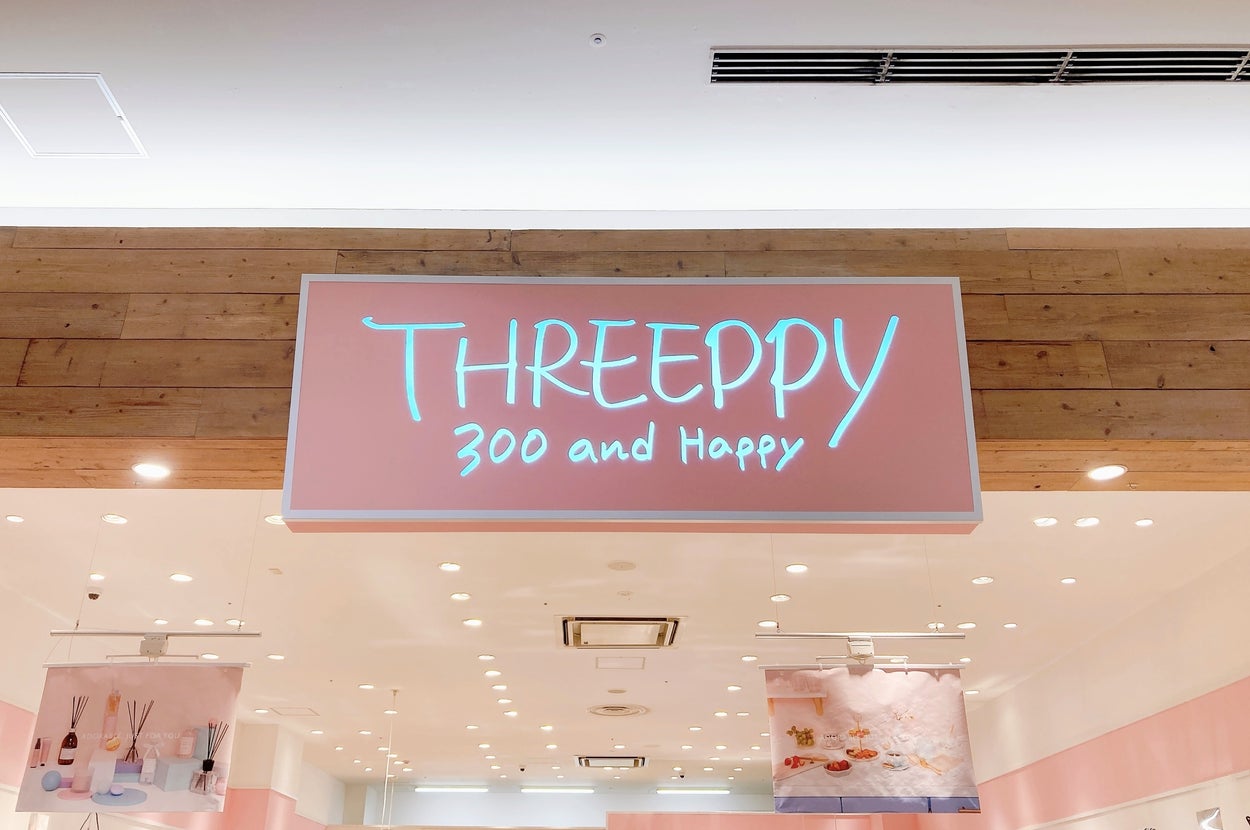 店の看板に「THREEPPY 300 and Happy」と書かれている室内の様子。