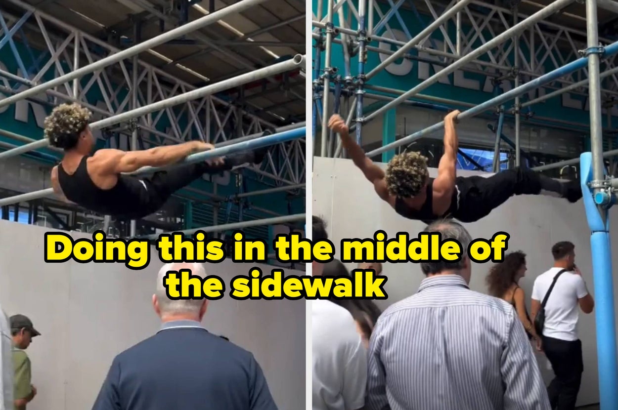 Man in athletic clothing doing pull-ups on sidewalk scaffolding, with people watching below. Text overlay says, "Doing this in the middle of the sidewalk"