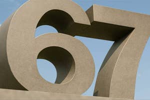 Large 3D numbers "67" against a clear sky background