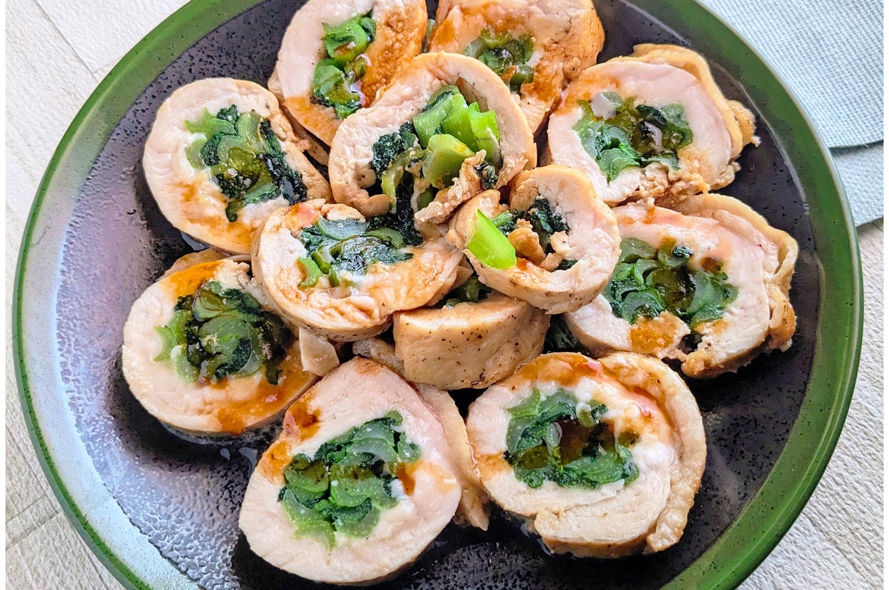 お皿に盛られた豚肉のロール。中に野菜が巻かれており、ソースがかかっている。