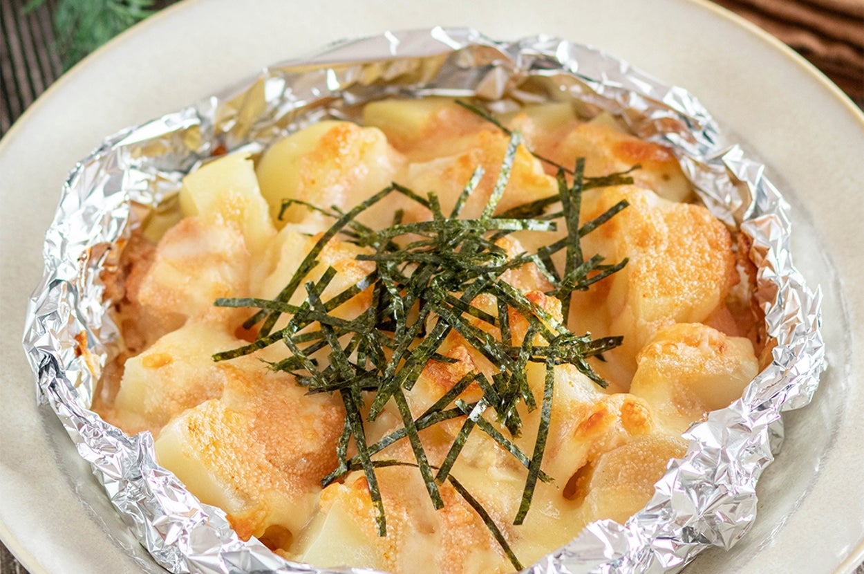 アルミホイルに包まれたチーズと海苔がのったポテトのオーブン焼き料理。