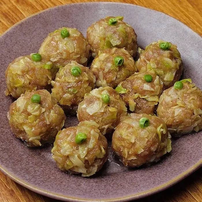 肉団子が皿に並んでいる。上にグリーンピースがトッピングされている。