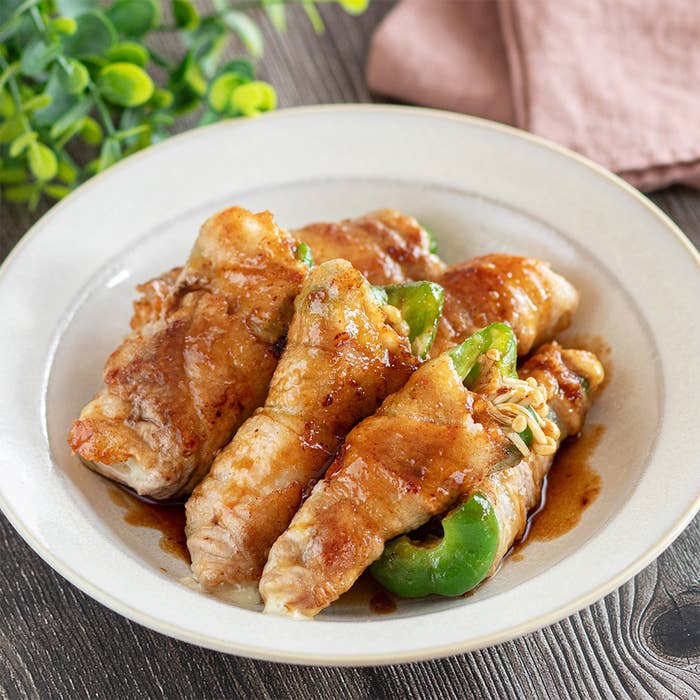 皿に盛られた肉で巻いた野菜の料理。ソースがかかっており、美味しそうに見える。食欲をそそるプレゼンテーション。
