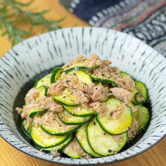 ズッキーニとツナのサラダが盛られたボウル。新鮮なハーブが添えられ、美味しそうに仕上げられている。