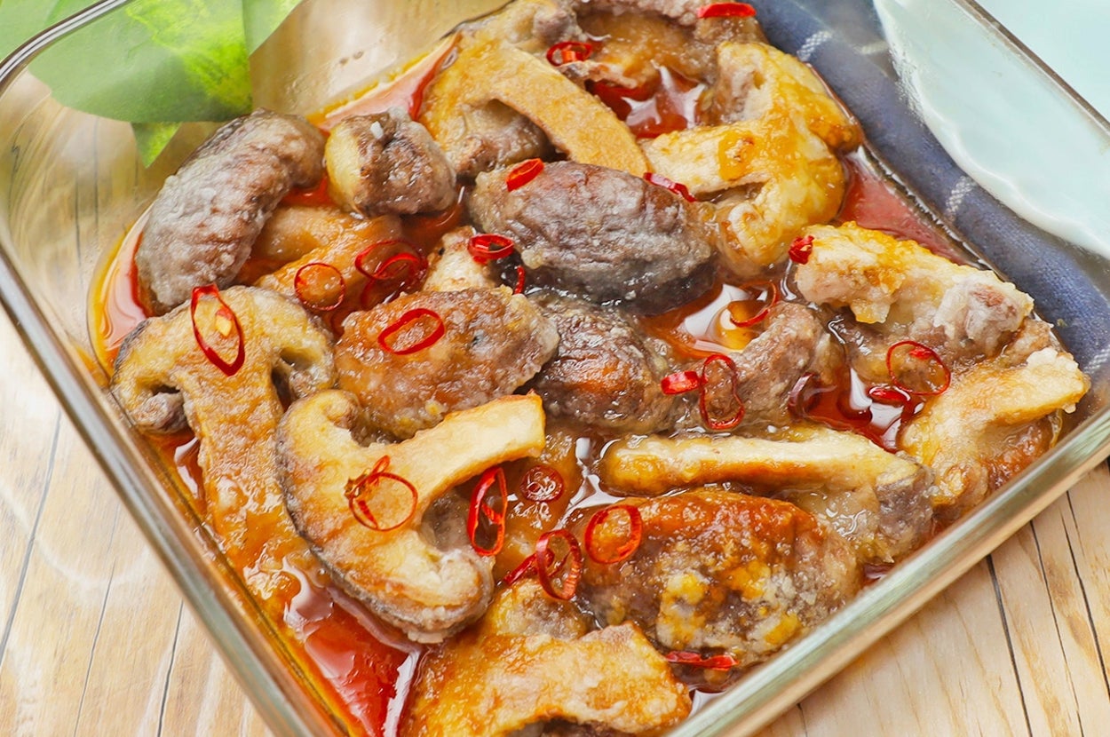 ガラス容器にきのこと赤唐辛子を使った煮込み料理が盛り付けられている。