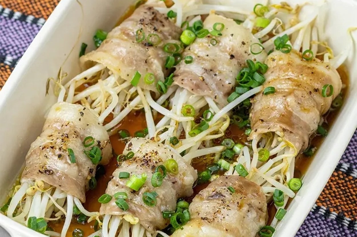 ビーンスプラウトを豚肉で巻いた料理がオーブン皿に盛られている。上には刻んだネギが散らしてある。