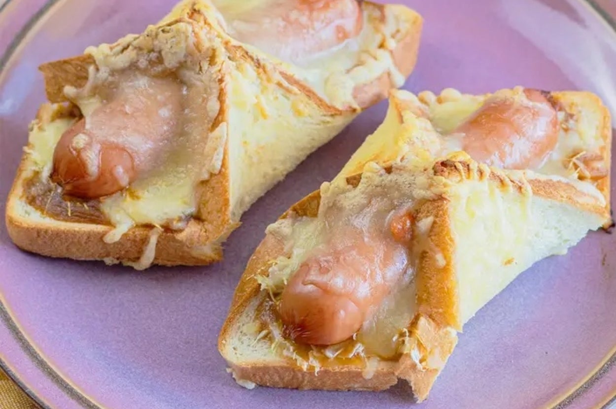 皿に乗ったパンの上にソーセージとチーズがのっている料理。