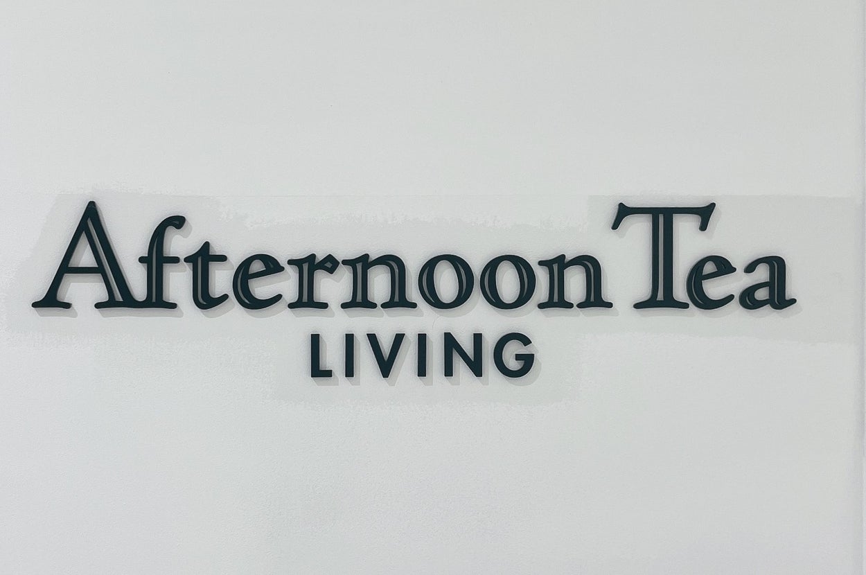 Afternoon Tea LIVINGのロゴが壁に描かれている。明るい室内の一角に位置している。