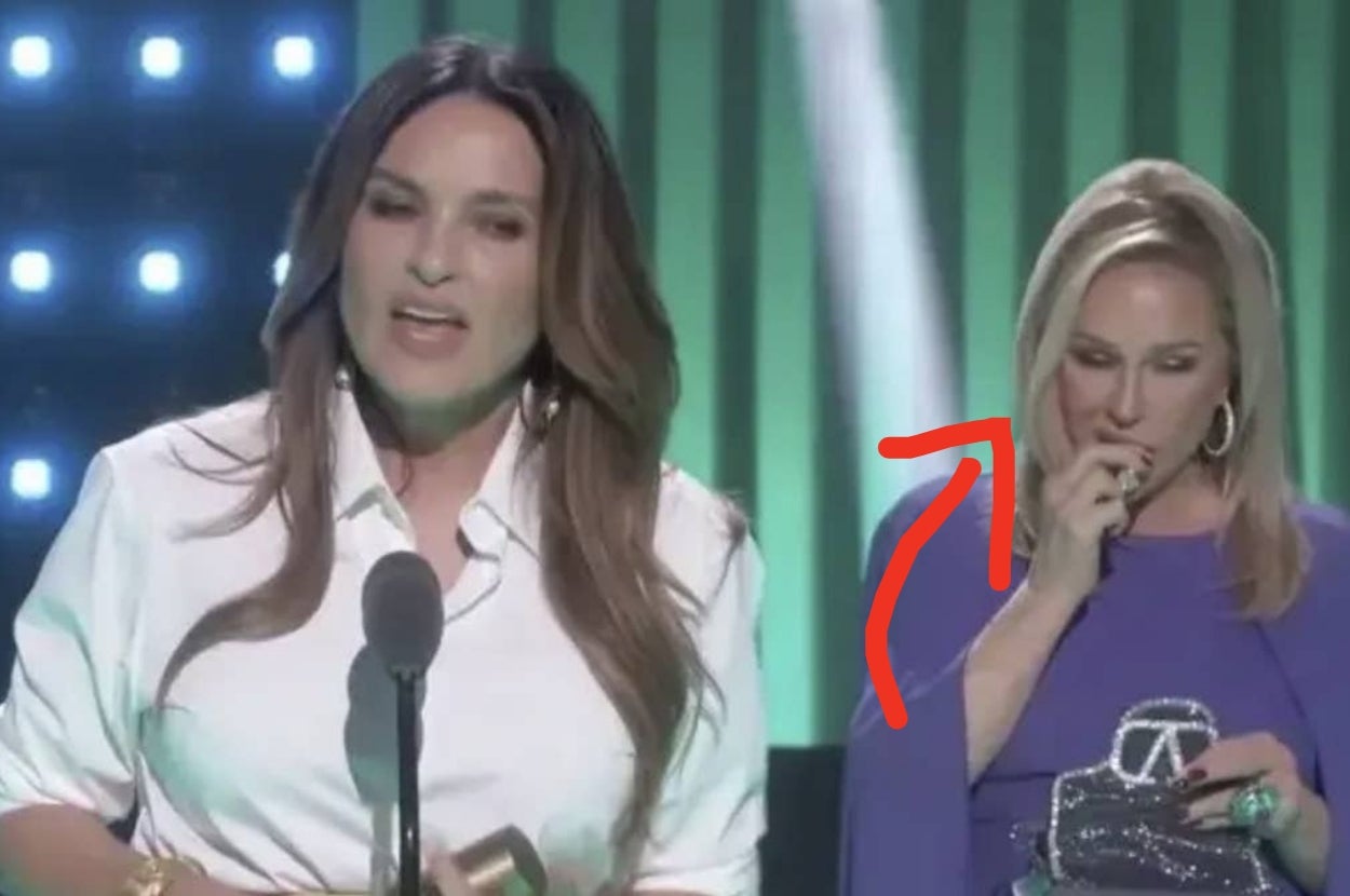 Kathy Hilton applying lipstick while Mariska Hargitay gives a speech onstage