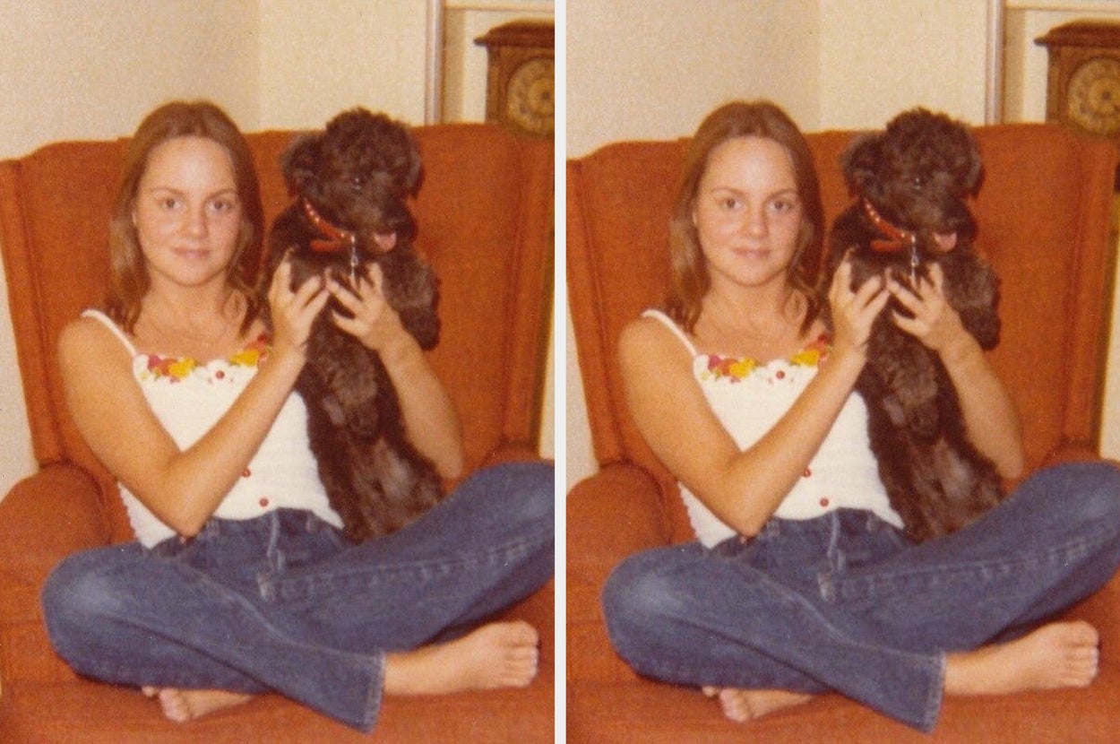 Person sitting cross-legged on a chair, holding a small dog, smiling at the camera