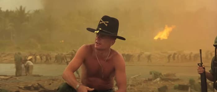 A shirtless antheral successful a subject chapeau kneels connected a battlefield arsenic soldiers determination successful the inheritance with fume and occurrence visible