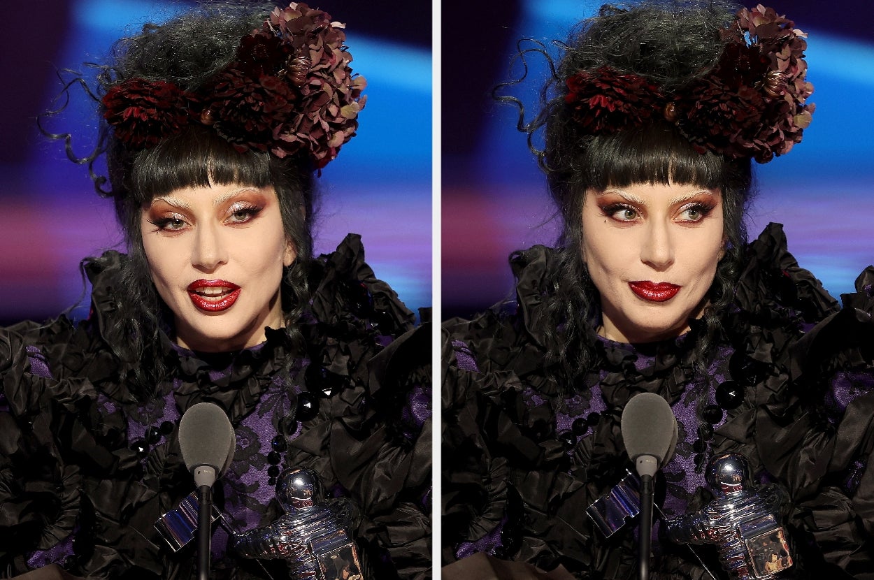 Person with elaborate updo and ruffled attire speaks at microphone