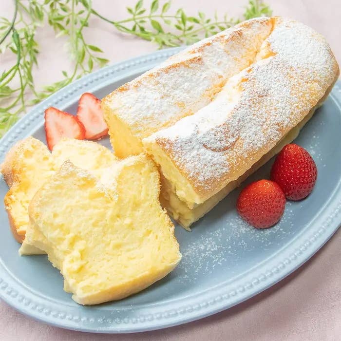 粉砂糖がかかったスフレケーキが切られ、イチゴが添えられて皿に盛られている。
