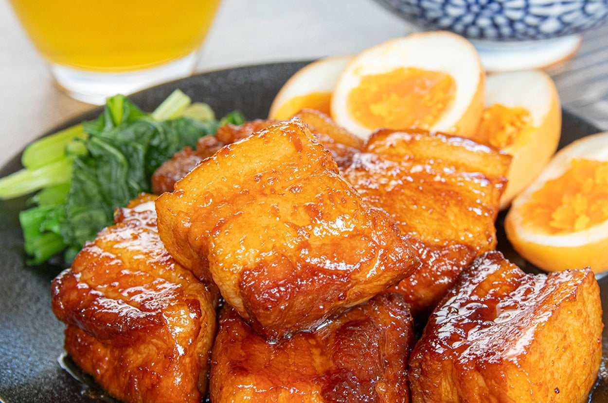 お皿に照り焼き豚の角煮、ゆで卵、ほうれん草。後ろにライスと飲み物。