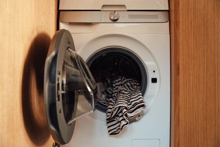 Front-loading washing instrumentality with an unfastened doorway and striped apparel inside