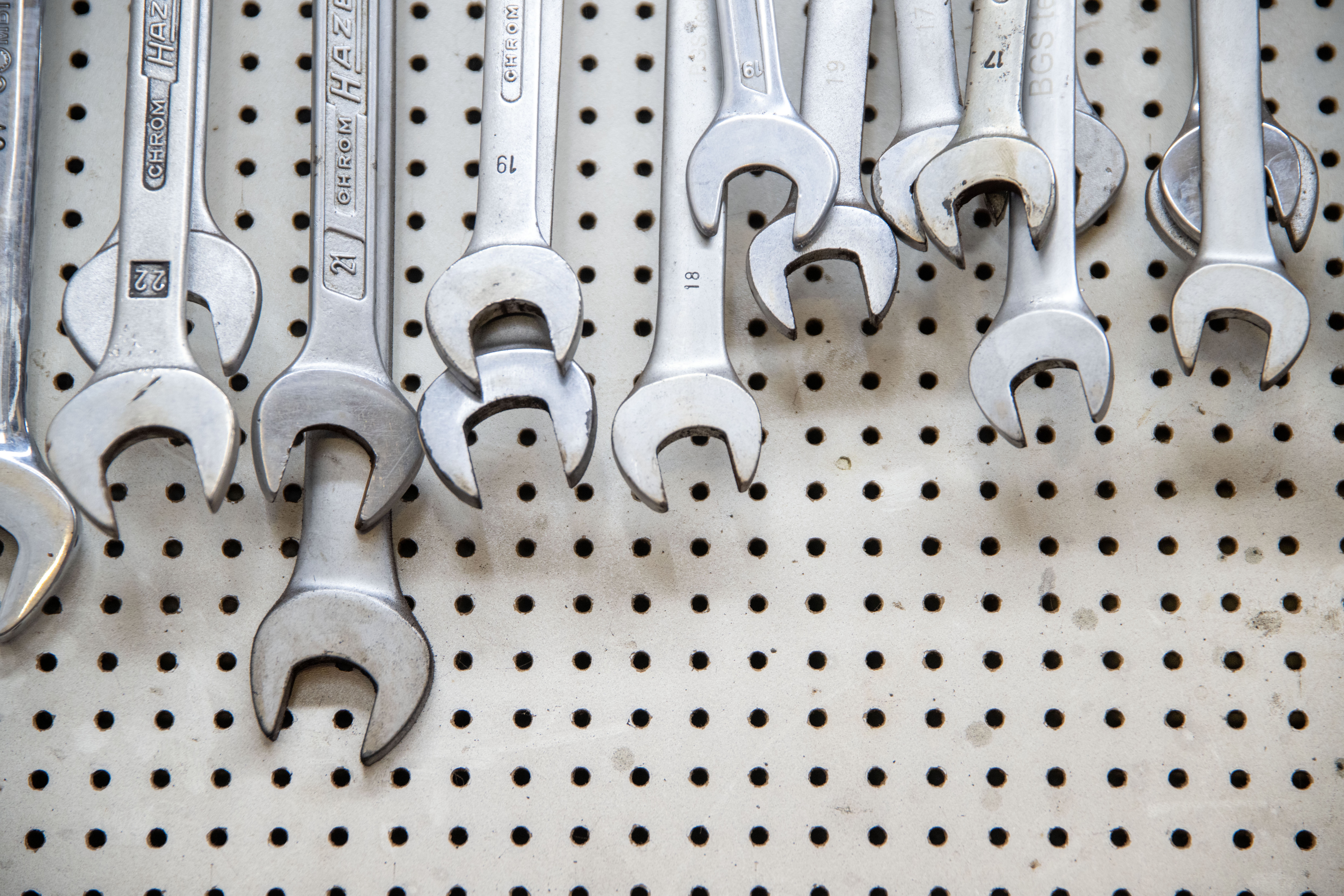 Skjønner i forskjellige størrelser som henger på en tavle i et verksted