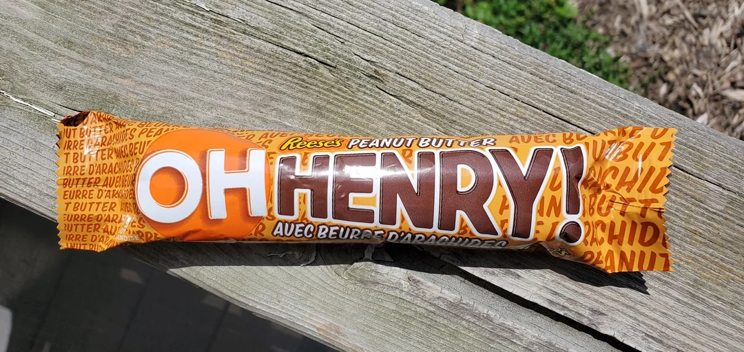 Åh Henry! Candy Bar med Reese ' s peanøttsmøremballasje på en treoverflate i sollys